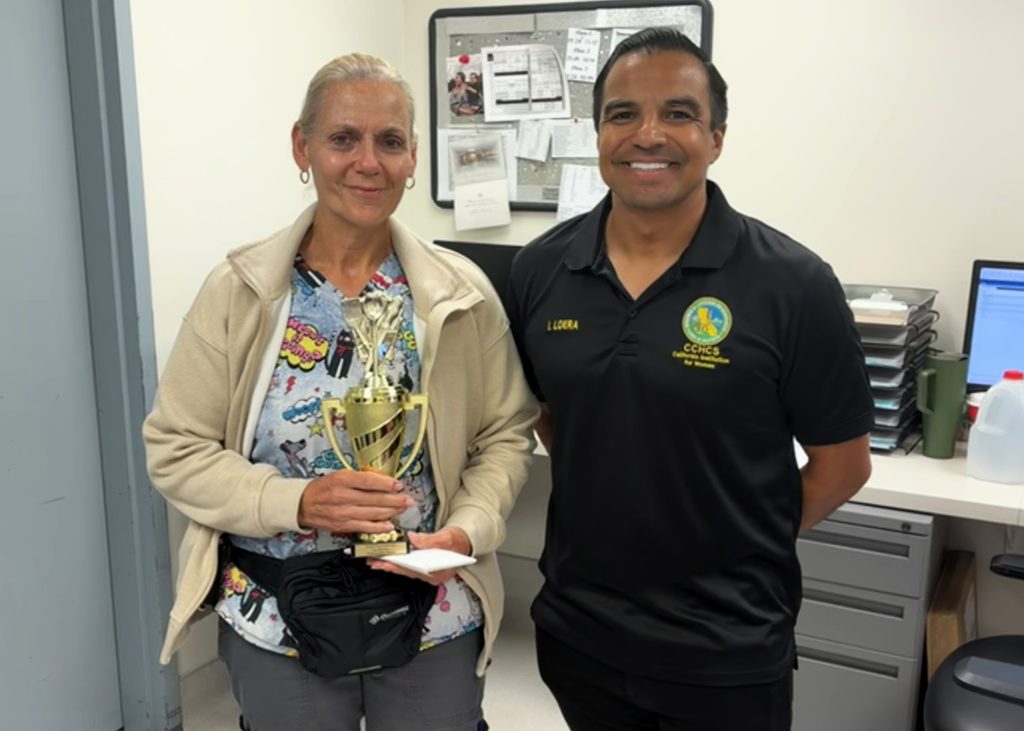 CIW bake sale winner with trophy and Employee Association President Loera