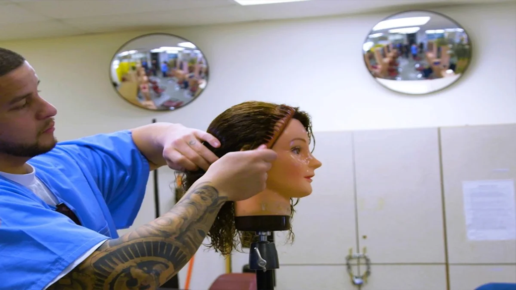 Incarcerated person hands-on learning in cosmetology class