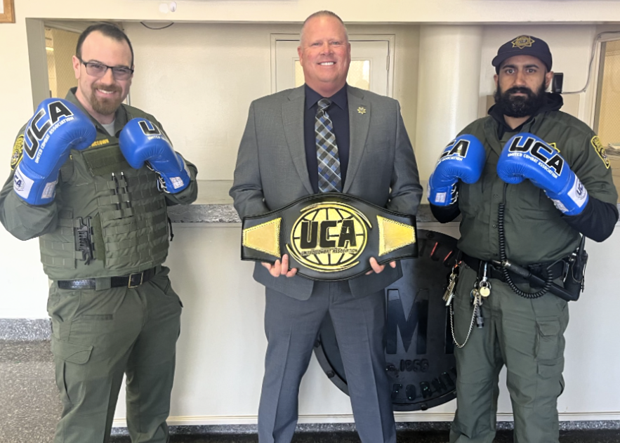 Officers pose in boxing gloves with Warden