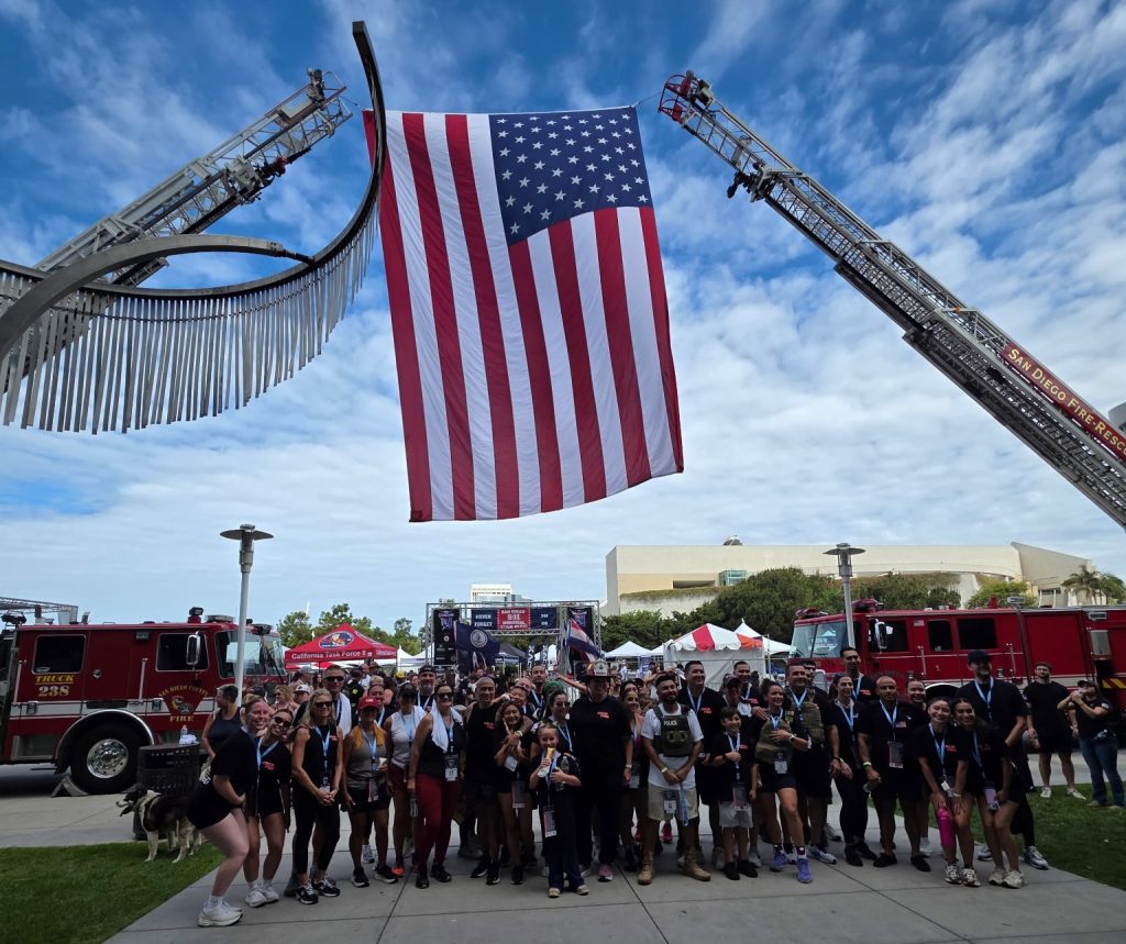 CDCR RJD staff under the flag at the memorial stair climb to honor lives lost during Sept. 11 terror attacks.