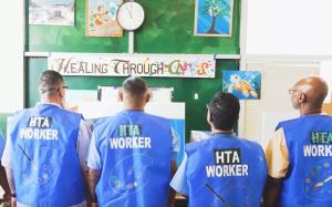 Four men in front of a sign that reads with Healing Through Arts.