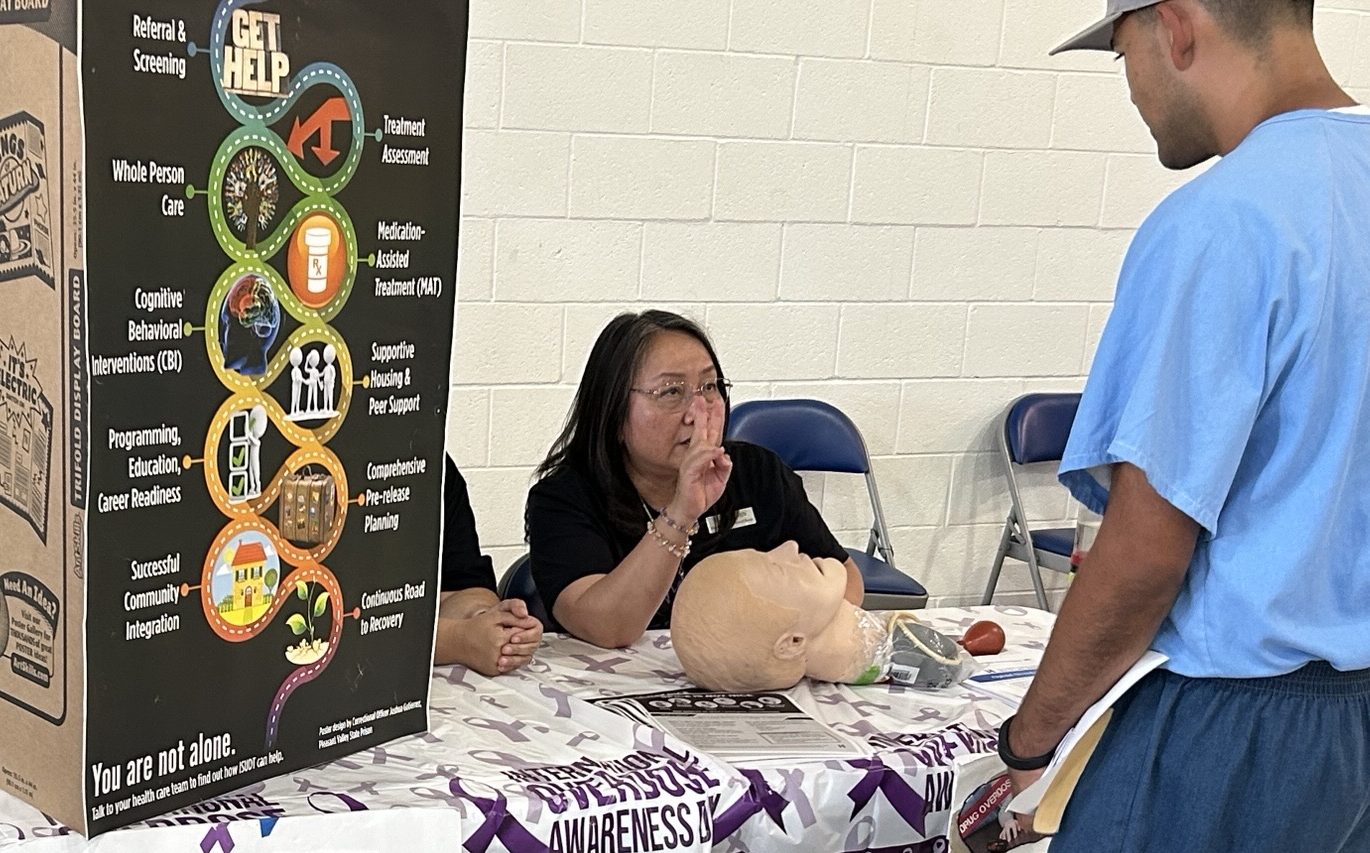 An incarcerated person learns more about how to administer Narcan medication to someone who has overdosed during the Valley State Prison health and wellness fair.