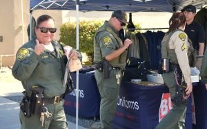 A correctional officer smiles while giving a thumbs-up at the Avenal State Prison staff health fair.