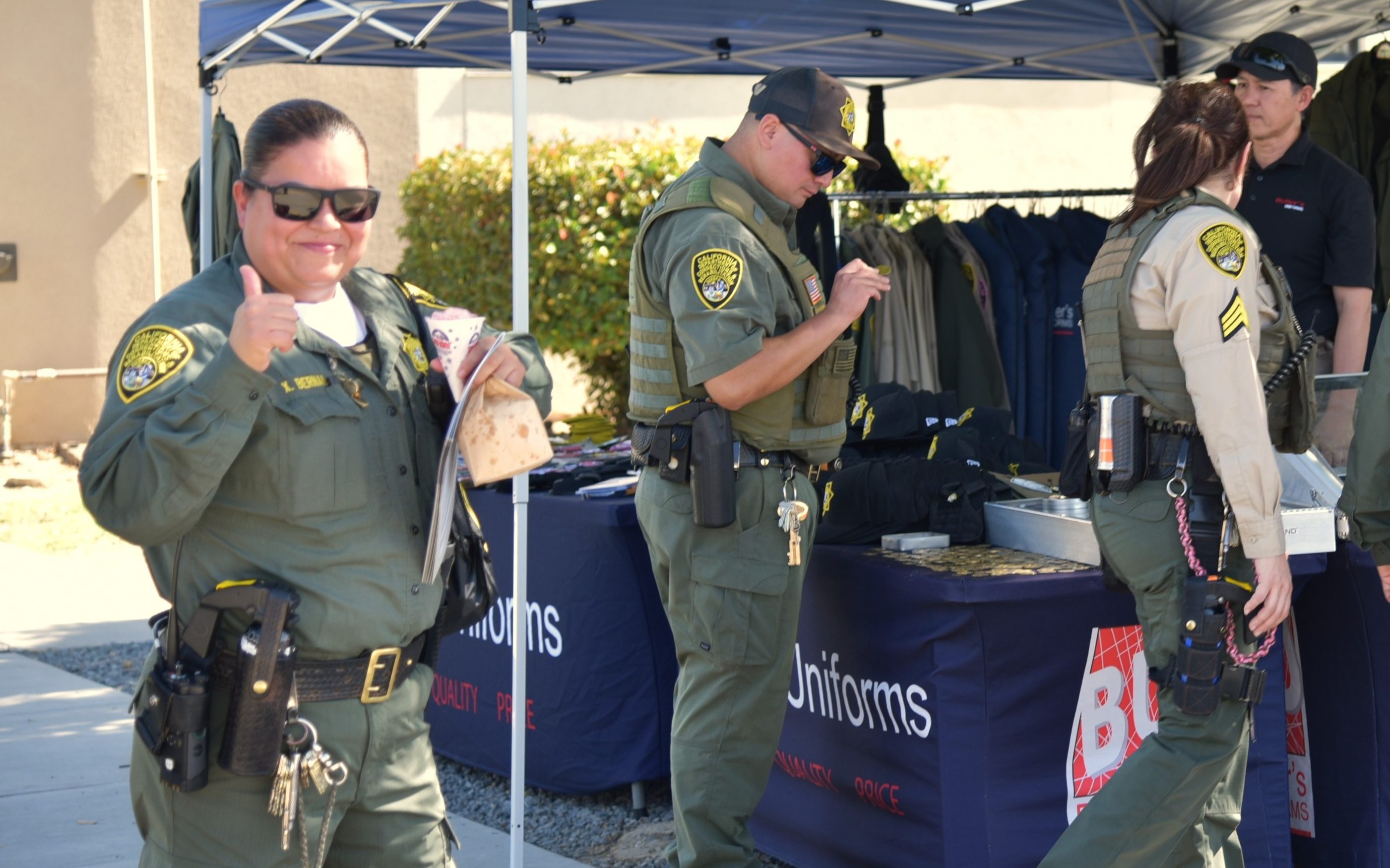 A correctional officer smiles while giving a thumbs-up at the Avenal State Prison staff health fair.