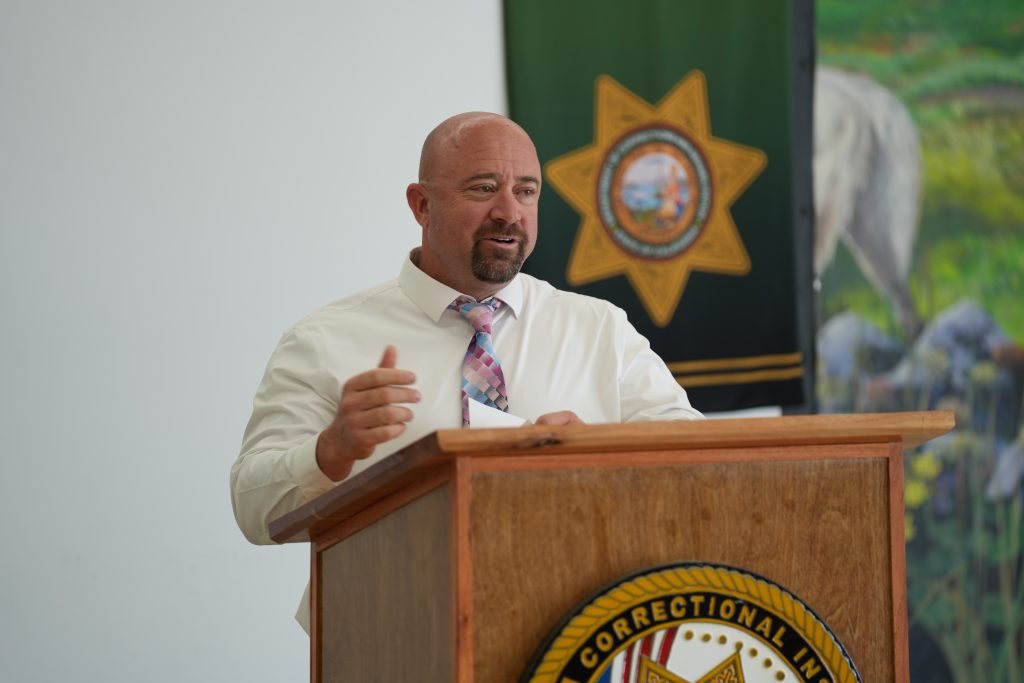 Person speaking at lectern ta CCI-Tehachapi.