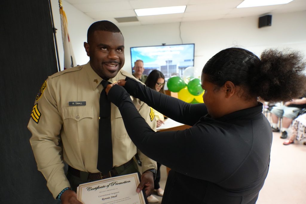 Pinning rank insignia on a recently promoted staff member.