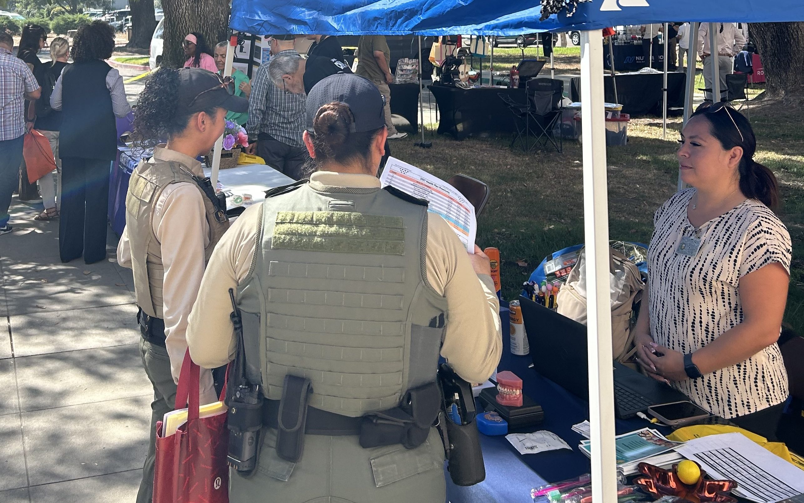 CIM staff health and benefits fair held Oct. 1, 2026, in Chino, California. Various information booths are shown on prison grounds near the parking lot.