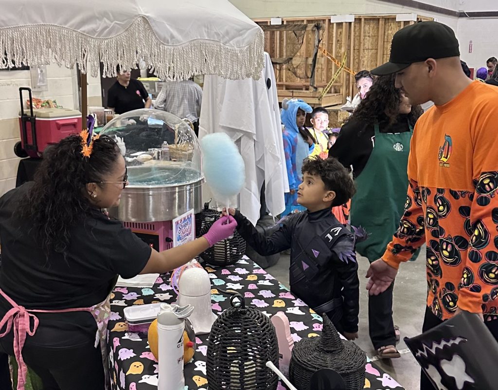 Child receives cotton candy at a Halloween event put on by CDCR and CTF-Soledad.