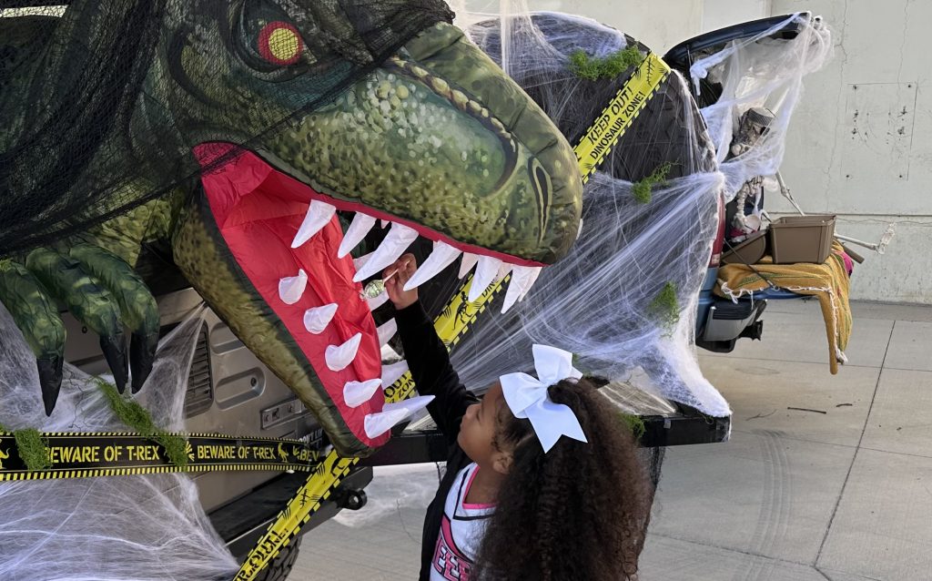 A child reaches into a T-Rex's mouth at CTF-Soledad during Truck-4-Treats, a Halloween event for staff, their families and friends.