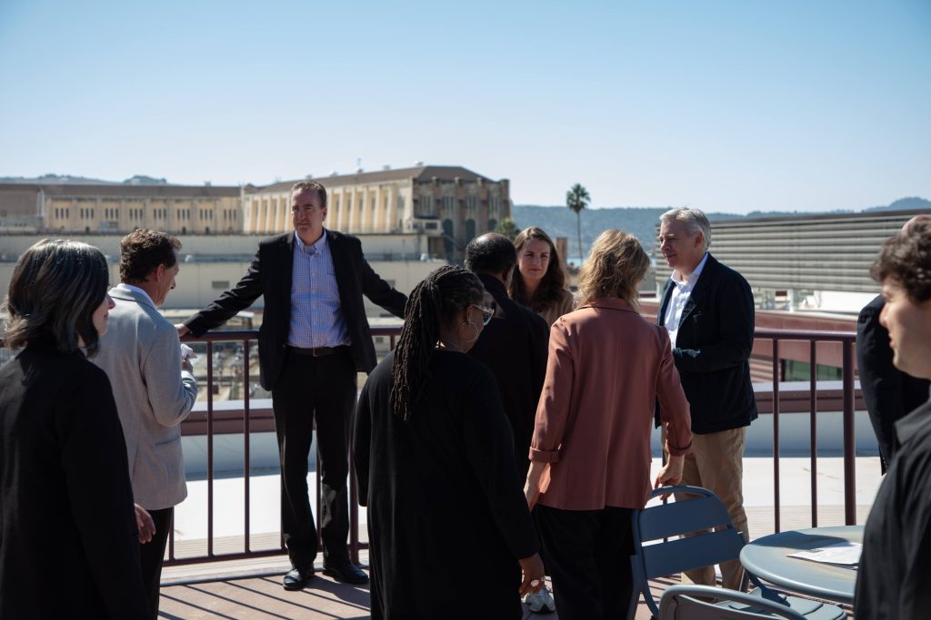 Secretary Jeff Macomber and others on a patio at the new SQ Learning Center.