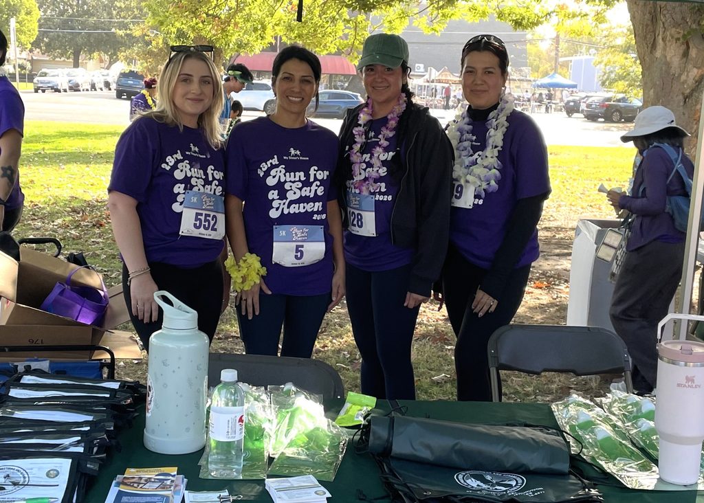 Office of Victim and Survivor Rights and Services staff at table for Run for a Safe Haven event