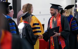 VSP college graduate is presented by degree by a representative of California State University, Fresno.