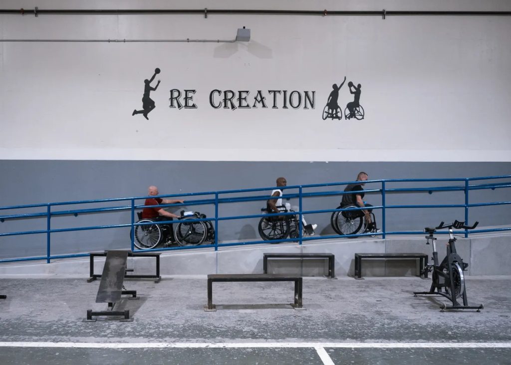 "Re Creation" painted on the gym wall above participants
