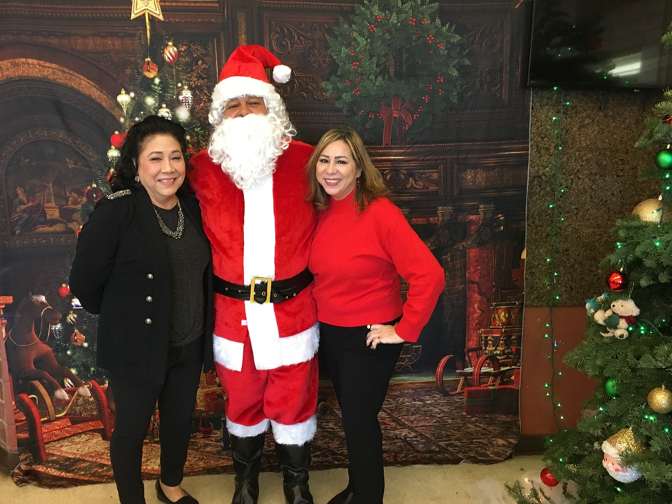 Superintendent Maria Harper (left) and Assistant Superintendent Jenny Dillon (right) standing with Santa Claus (center).
