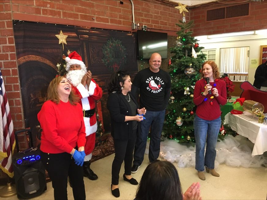 Retiring Asst. Superintendent Jennie Dillon laughs as DJJ Director Heather Bowlds honors her and retiring Superintendent Maria Harper while Santa Claus and Deputy Director Jason Lowe look on.