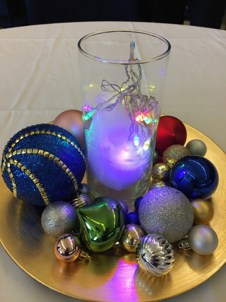 At Ventura’s holiday brunch, each table had a centerpiece of decorative glass balls on a charger with a large glass votive with battery powered lights inside. 