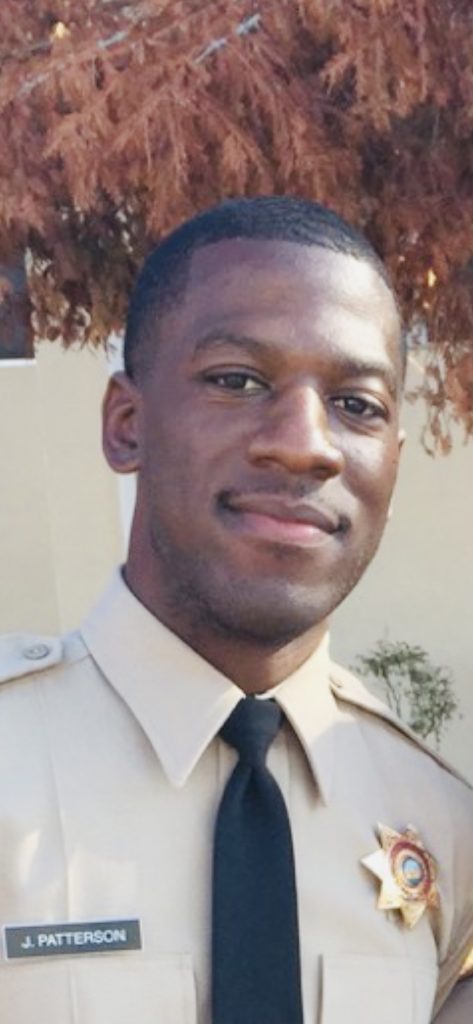 Man in uniform smiling.