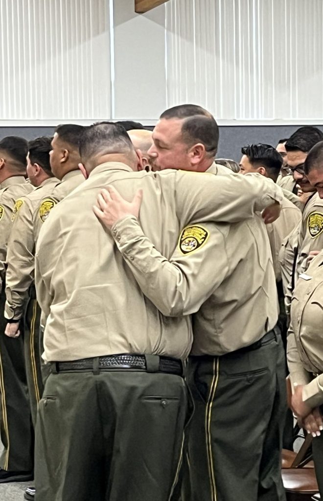 Cadets celebrate by hugging at the completion of the ceremony. 