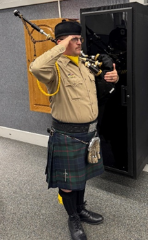 Picture of bagpiper standing at attending during the presentation of colors
