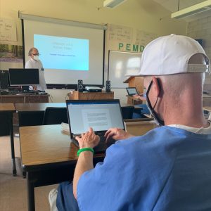 an incarcerated man using a laptop in a rehabilitative program