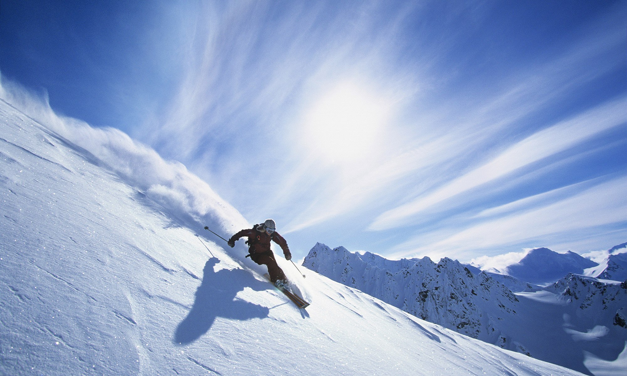 Fresh snow mountain with a skier under a  blue clear sky