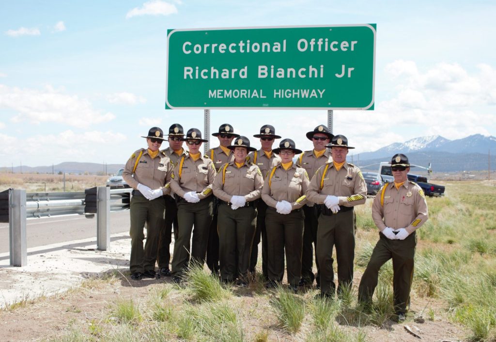 Correctional Officers standing in front of Richard Bianchi Jr highway dedication sign