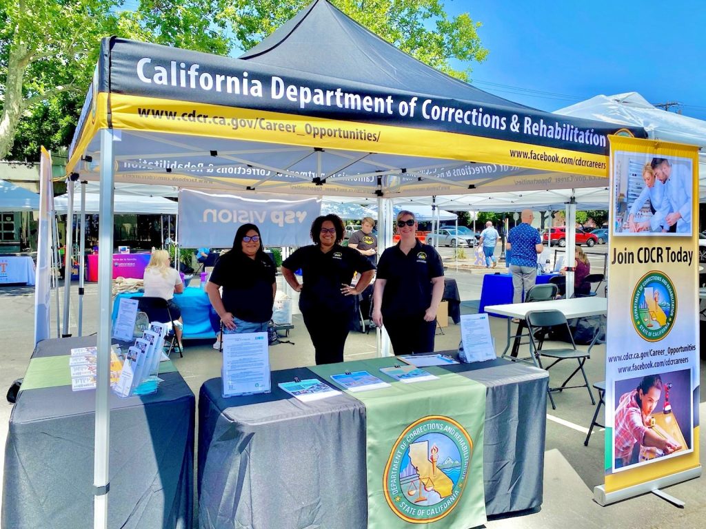 Three CDCR employees at a recruitment booth.
