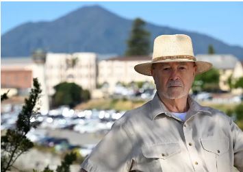 A man in a khaki shirt and hat outside San Quentin State Prison
