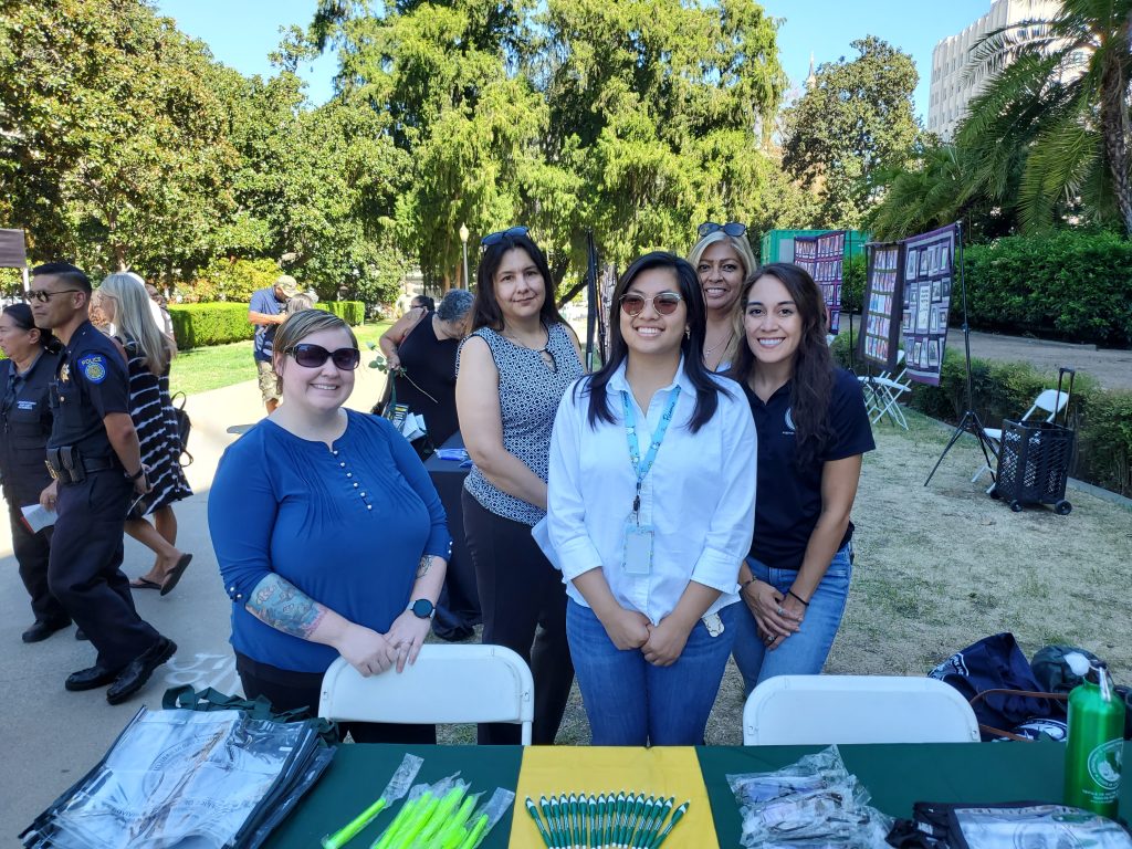 Victim Services Staff at information table in front of the State Capitol.