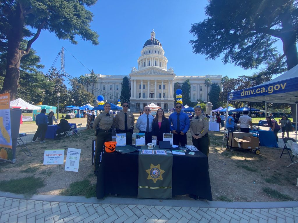 Correctional Staff standing at a information table in from of the California State Capitol