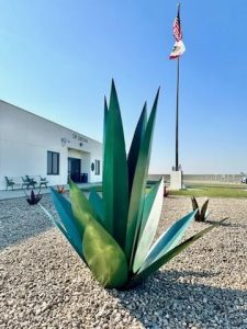 A decorative plant made out of metal, outside a prison administration building.