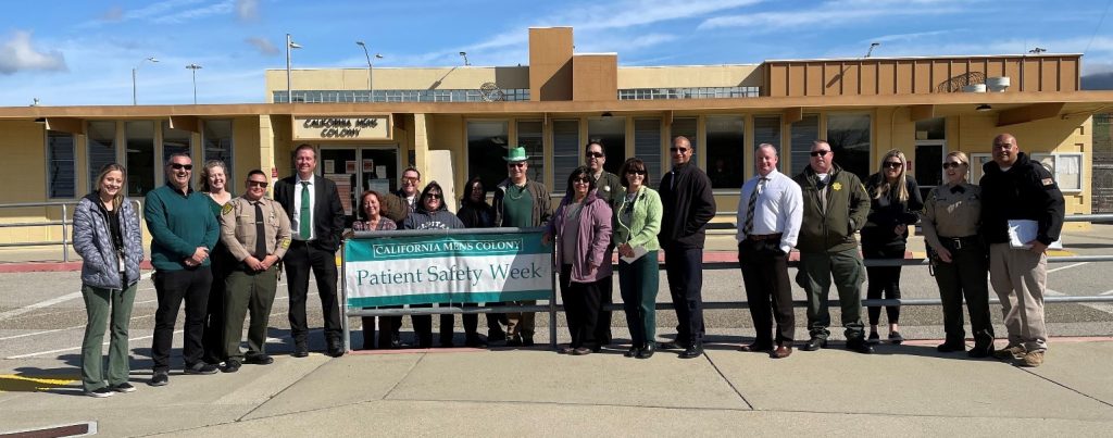 A large group of people with a Patient Safety Week banner