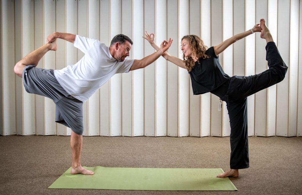 A man and a woman do yoga