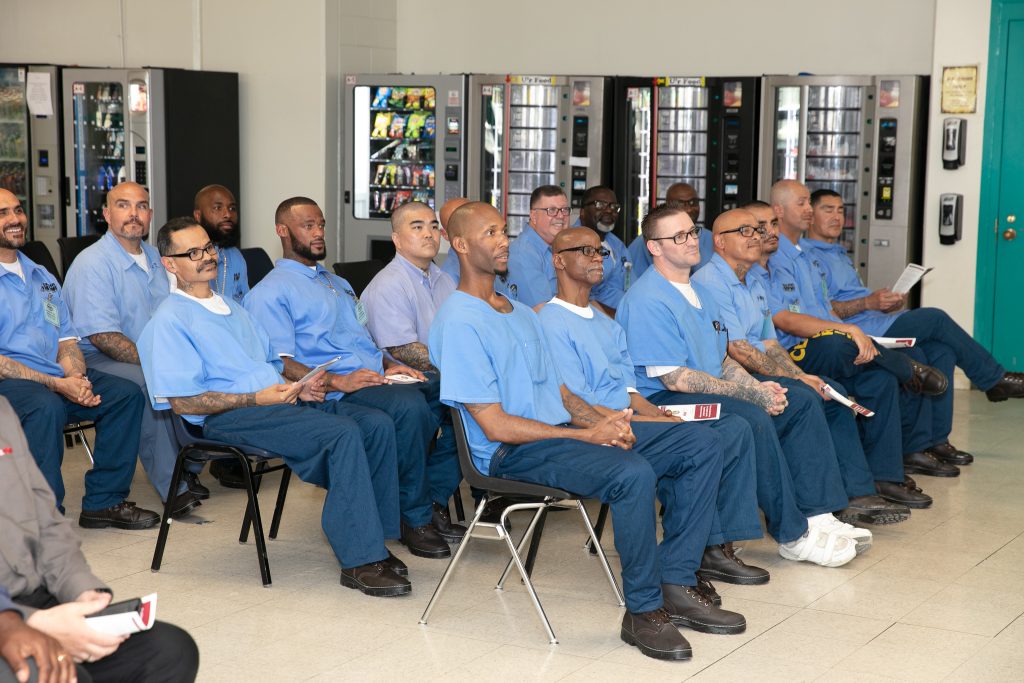 Incarcerated people sit together at ceremony