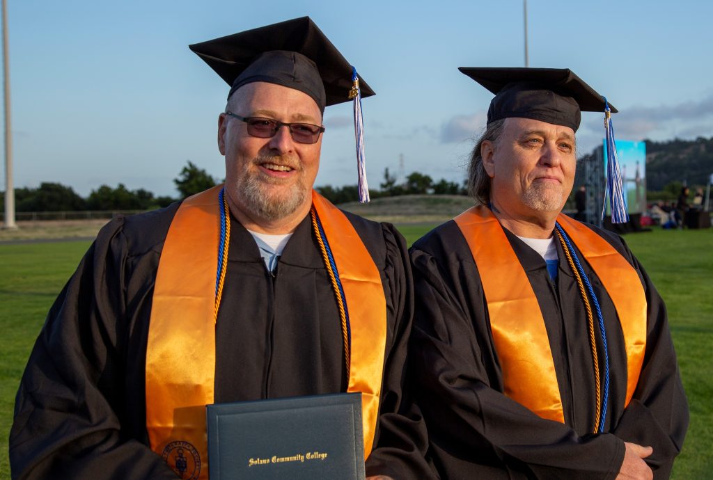 two CMF graduates in graduation cap and gown