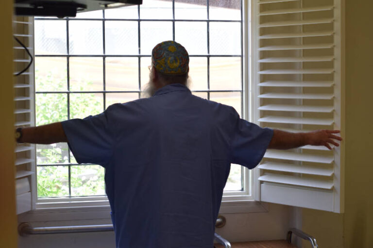 incarcerated man standing at open window