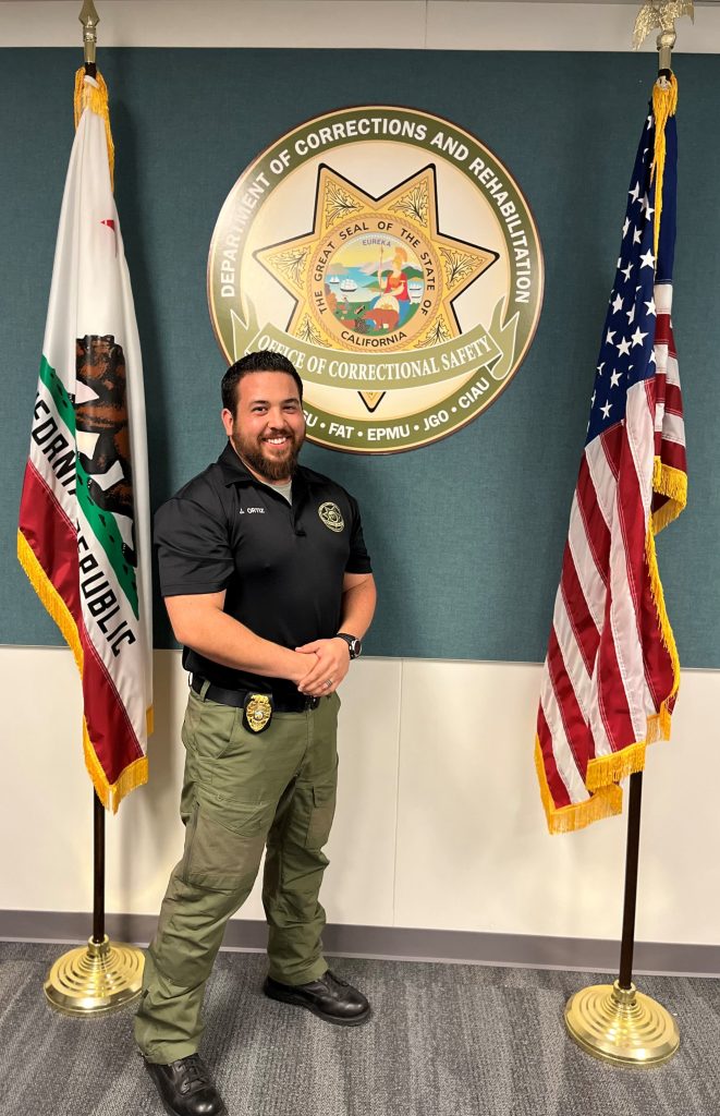 photo of Jason Ortiz in front of CDCR emblem