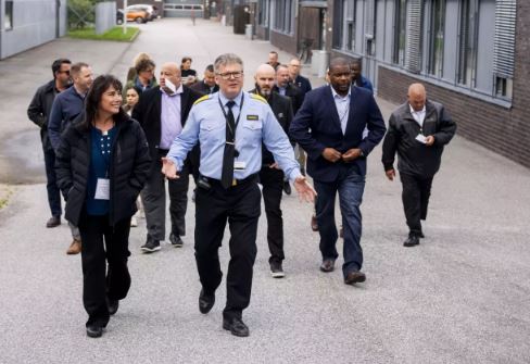 A correctional officer leads a group on a tour