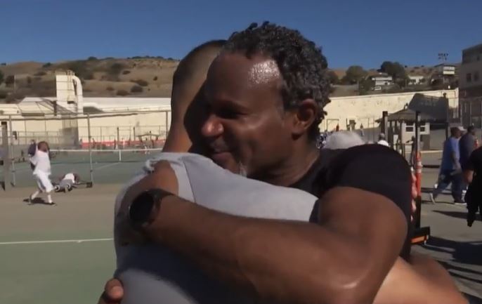 Two men hug on a basketball court